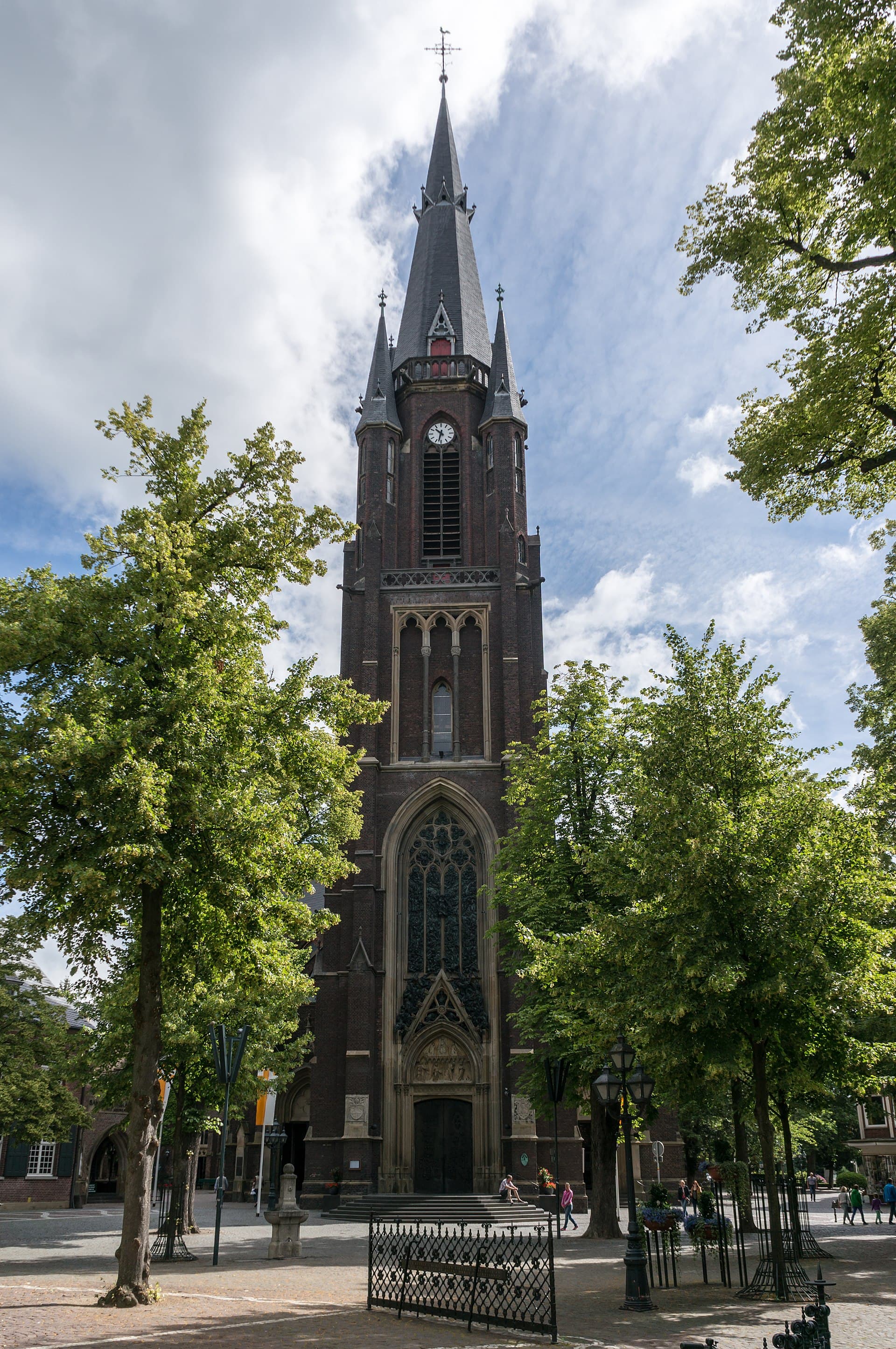 Backsteinerne, neugotische Marienbasilika in Kevelaer mit ihrem hohen Westturm vor blauem Himmel